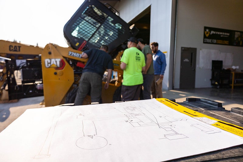 Peterson Cat team members working on a machine