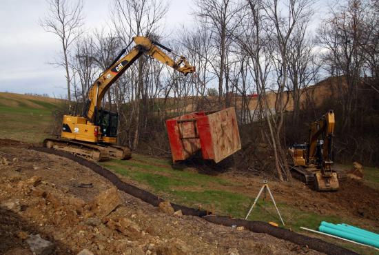 Site clean-up with coupler, bucket and thumb. Site clean-up with coupler, bucket and thumb.